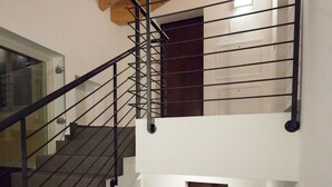 Eine mehrstufige Treppe mit schwarzen Geländern und Holzbalken.