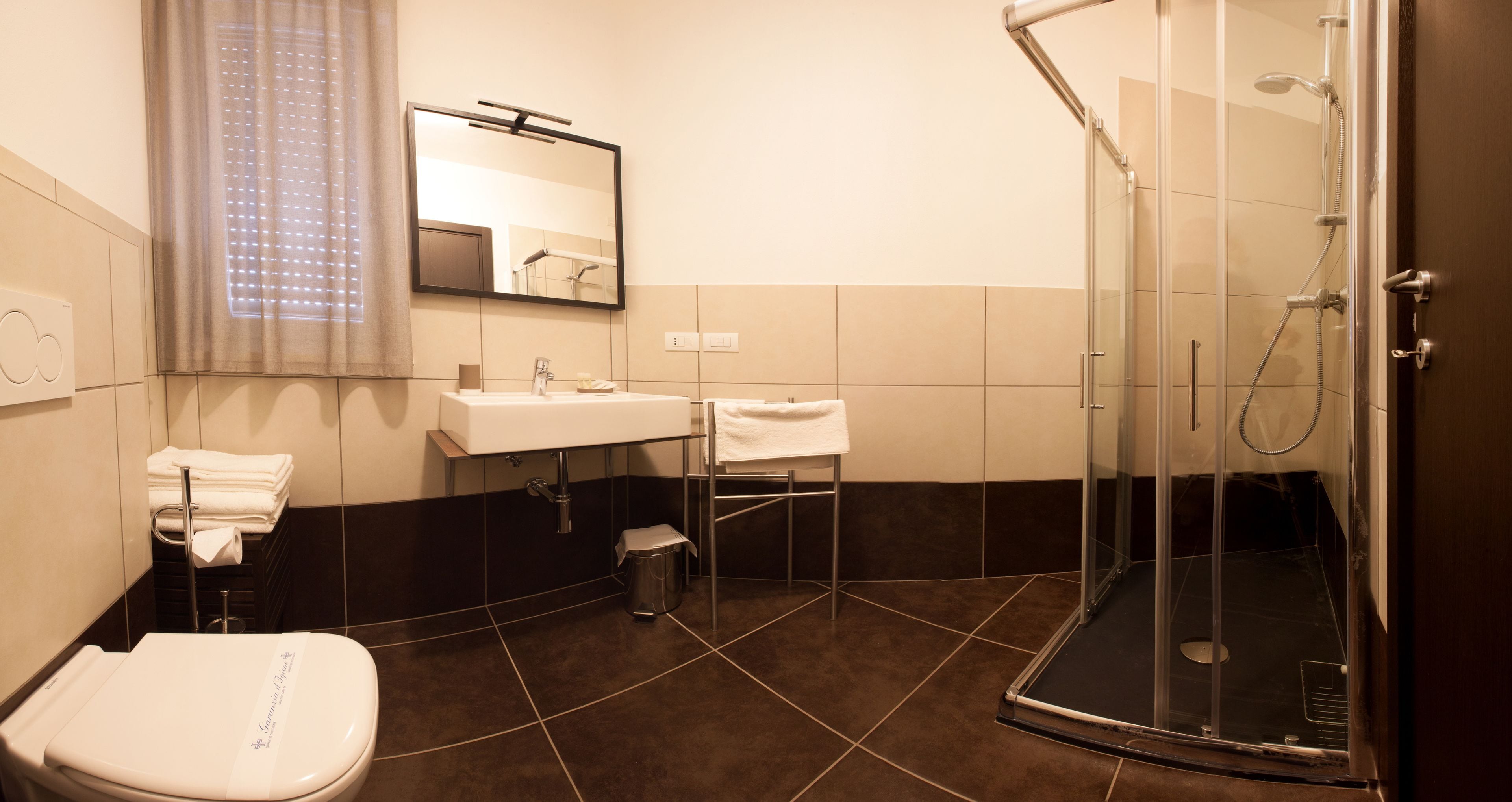 A modern bathroom with a toilet, sink, and shower.