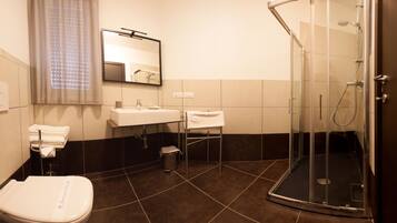 A modern bathroom with a toilet, sink, and shower.