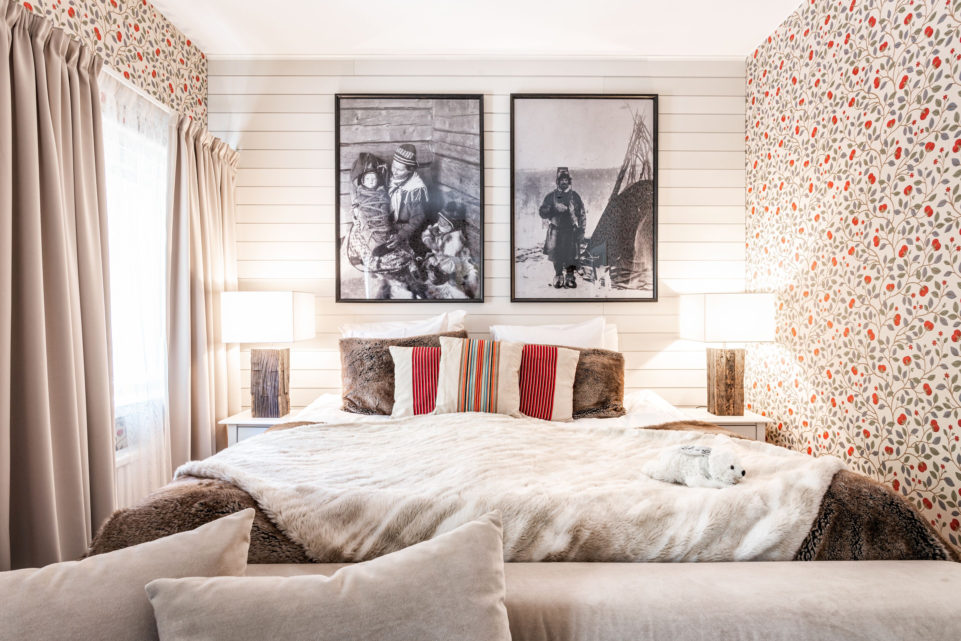 Ein Schlafzimmer mit einem großen Bett, zwei Nachttischen und zwei gerahmten Bildern an der Wand.