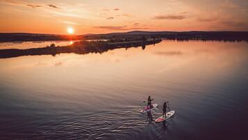 A calm lake at sunset with paddleboards.