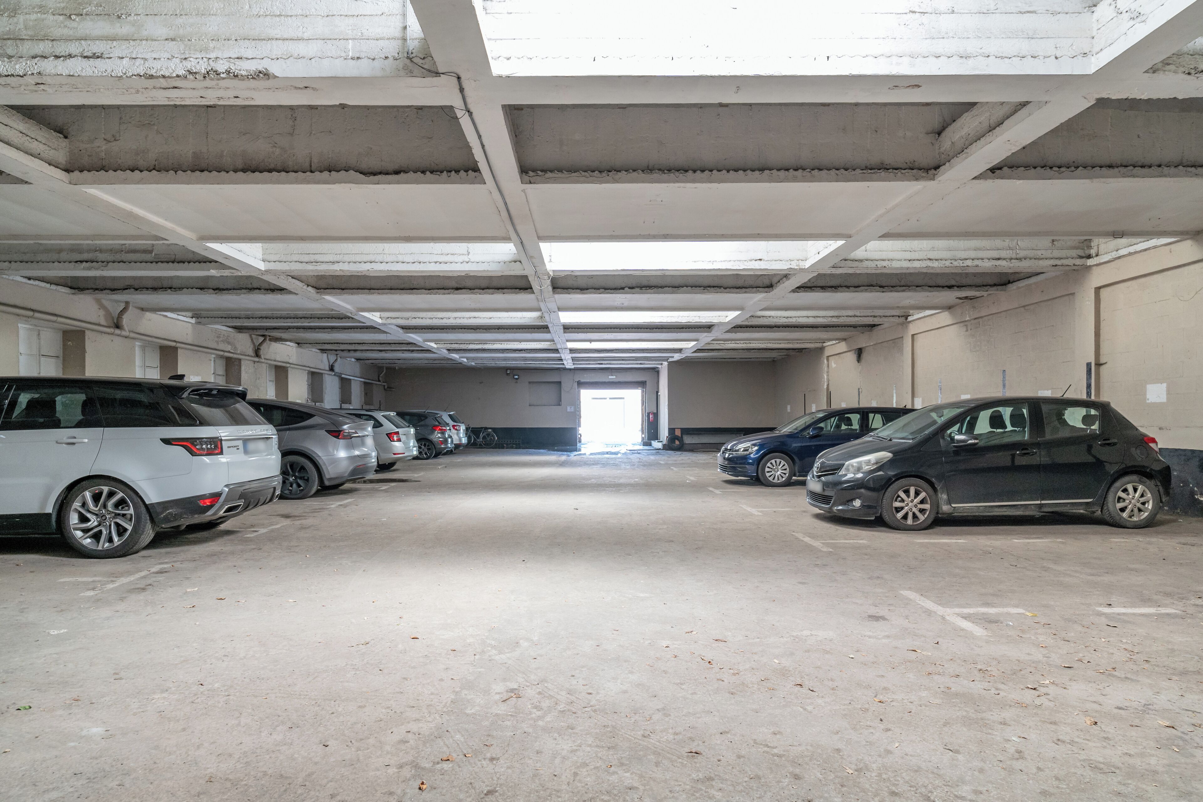 Un parking où de nombreuses voitures sont garées en rangées.
