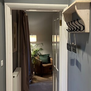 Enter a cozy room with a comfortable chair, green cushion, and a radiator for warmth.