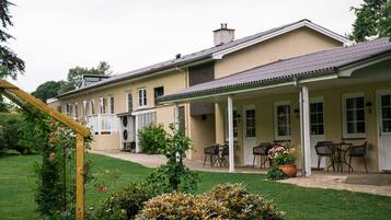 Guests can enjoy outdoor seating on the covered patio with tables and chairs, accessible via stairs.