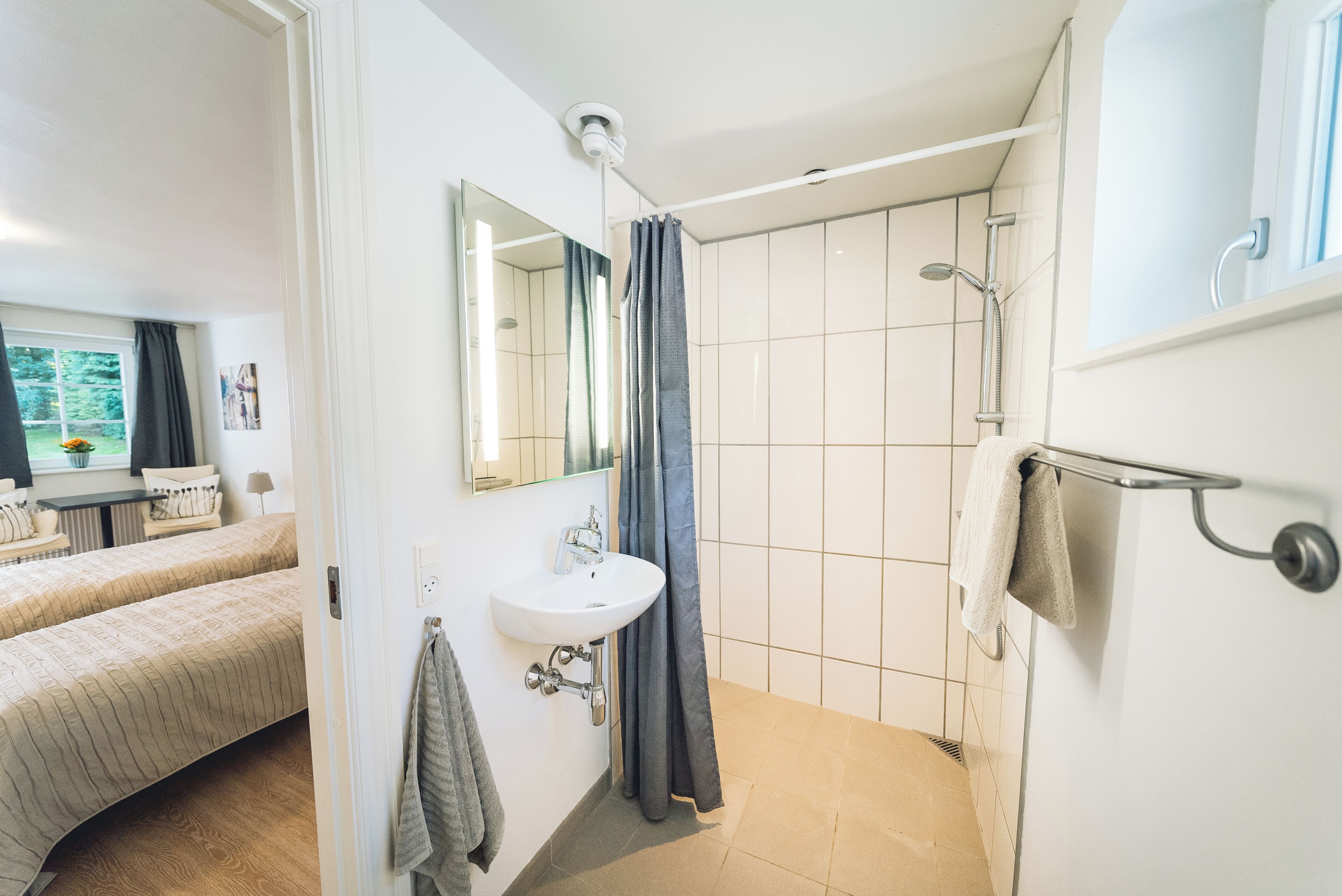 A modern bathroom with a shower, sink, and mirror.