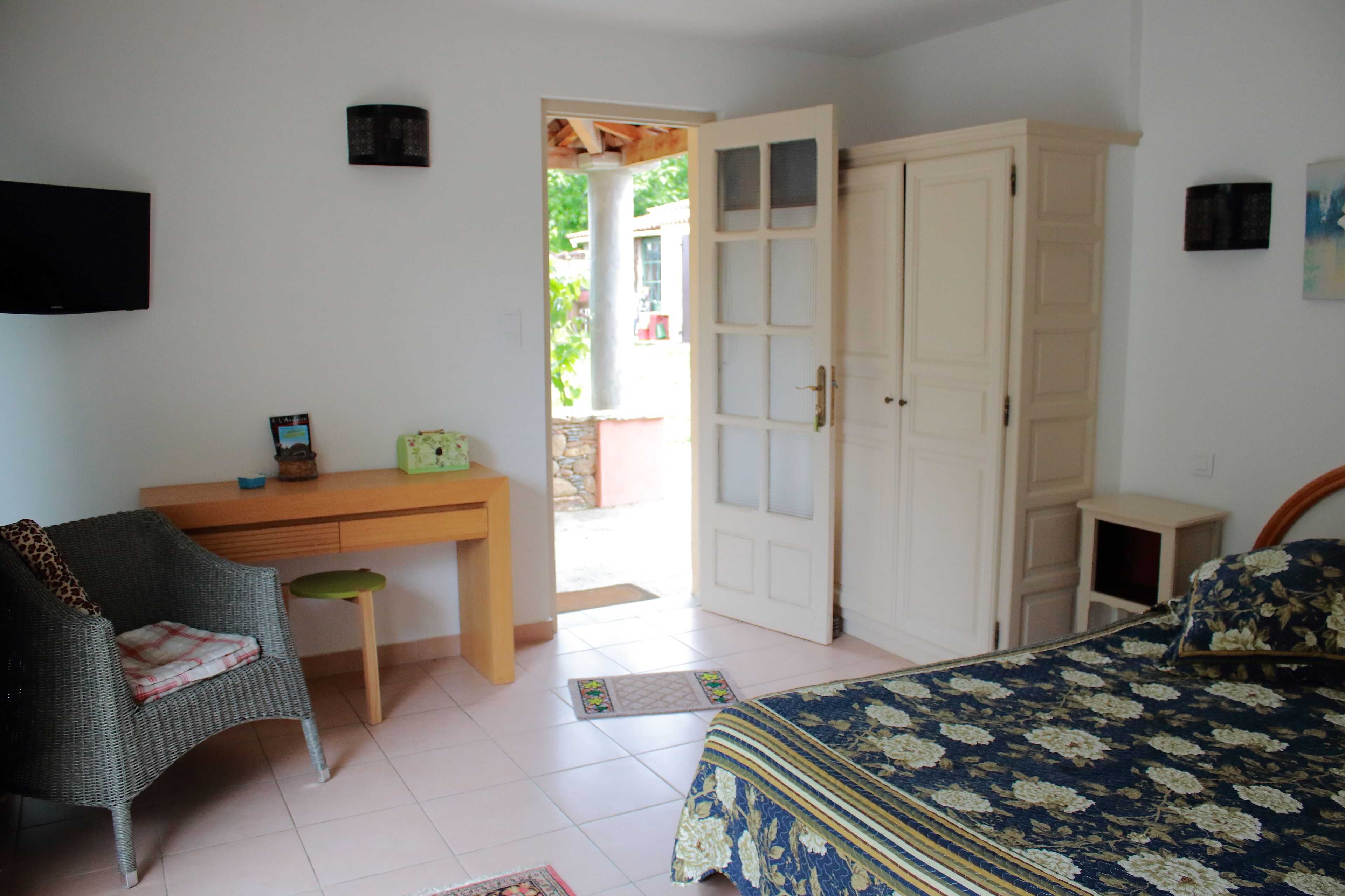 Un dormitorio con cama, escritorio, silla y armario.