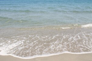 Uma praia com águas cristalinas e ondas suaves.