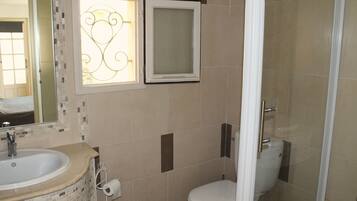A bathroom with a sink, toilet, and shower.