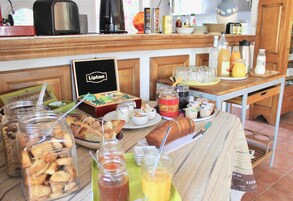Um buffet de café da manhã com diversos alimentos e bebidas.