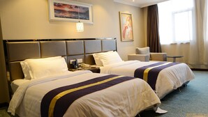 A hotel room with two beds, a nightstand, a chair, and a painting on the wall. - Best Western Yantai Hotel (Yantai)