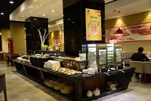 A buffet setup with various food items and a beverage station.