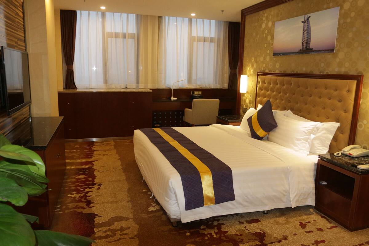 Ein Hotelzimmer mit einem großen Bett, einem Schreibtisch und einem Stuhl.