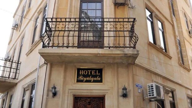 A hotel facade with a balcony, a sign reading "HOTEL Boyukqala," and an air conditioning unit. - Boyuk Gala Hotel (Baku)