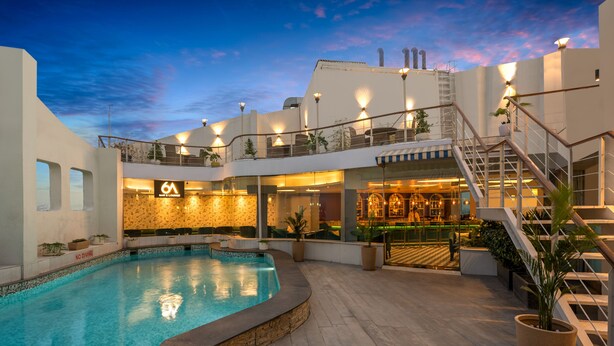 A pool area with a bar and lounge, outdoor seating, and a staircase leading to an upper level. - Park Inn by Radisson New Delhi IP Extension (New Delhi)