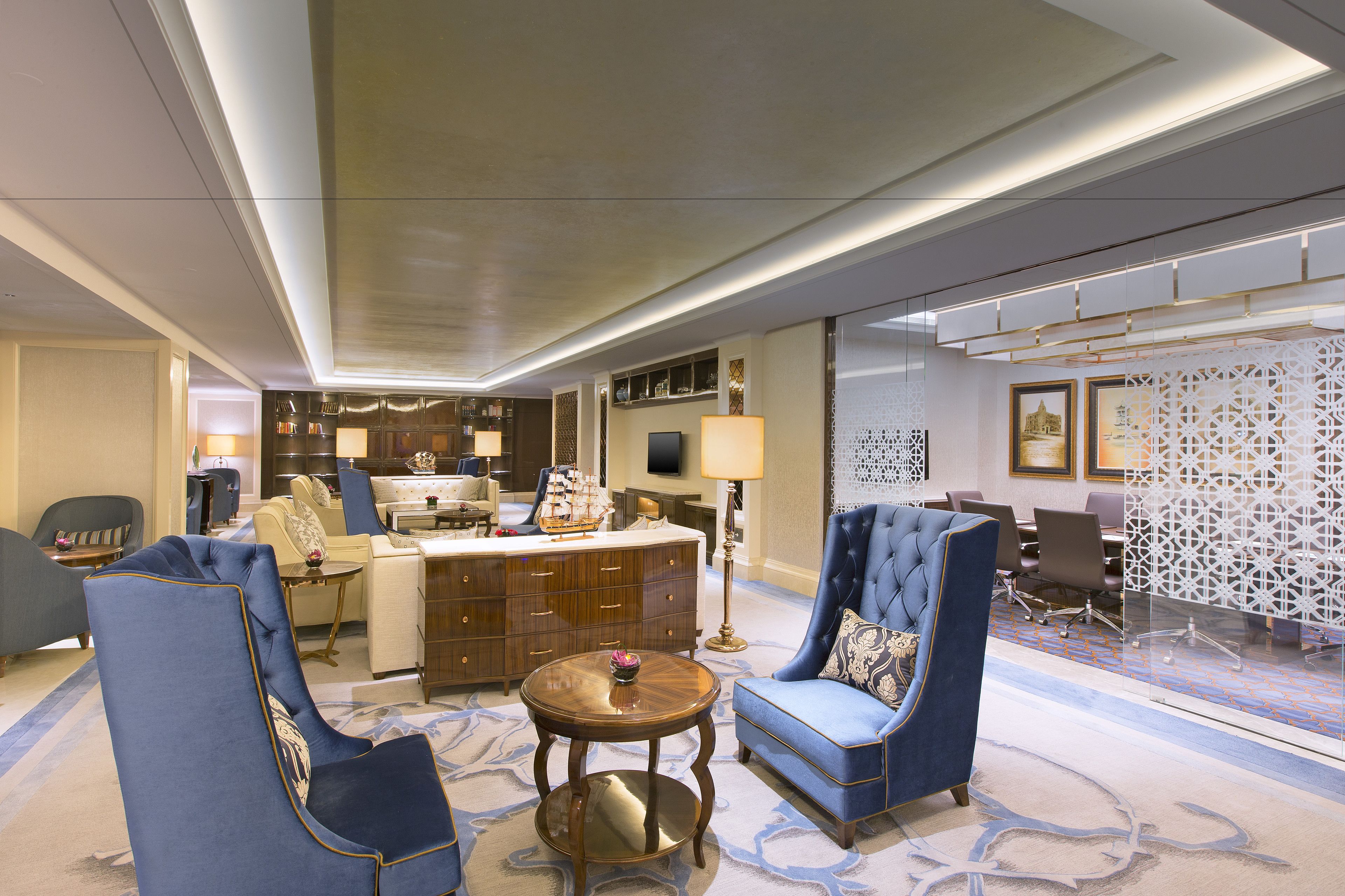 A spacious lobby with a grand piano, a large round table, and elegant seating arrangements.