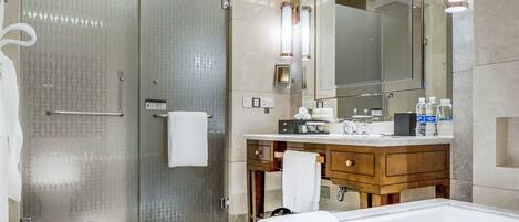 A modern bathroom with a glass shower enclosure, a wooden vanity, and a large mirror.