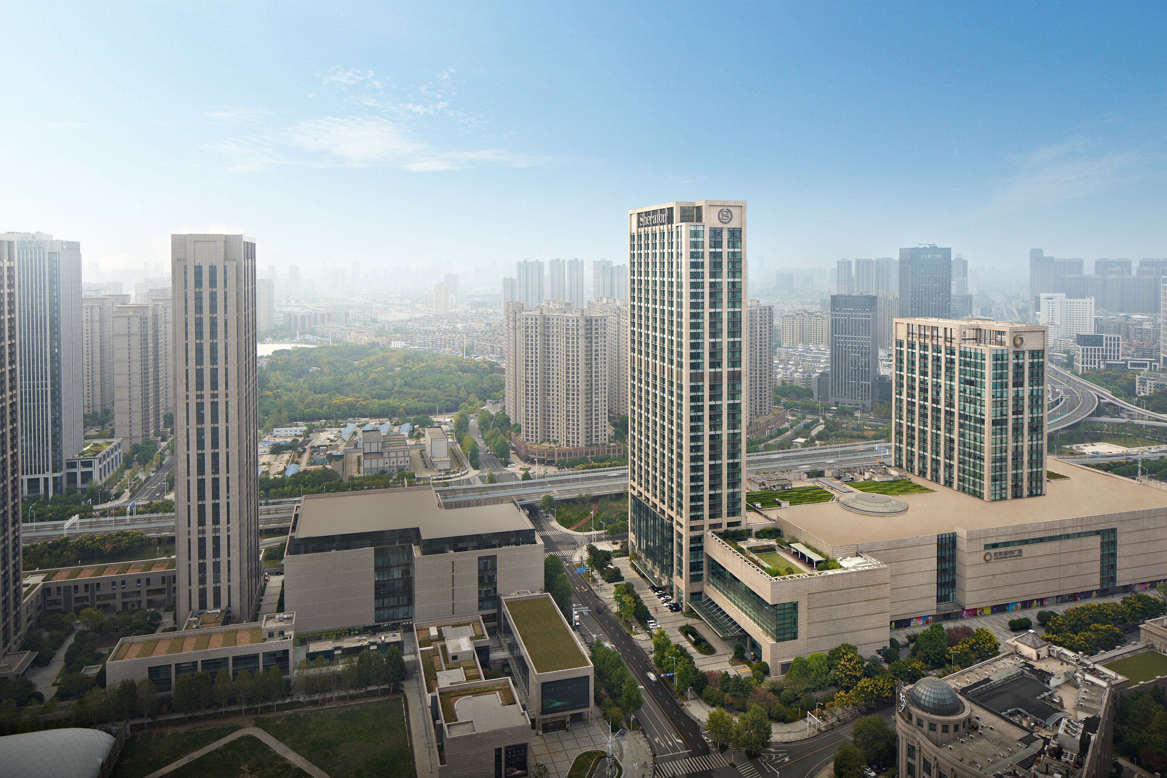 A high-rise building with a modern architectural design, surrounded by other high-rise buildings and a well-maintained urban environment.