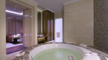 A spacious bathroom with a large bathtub, a separate shower area, and a vanity with a sink.