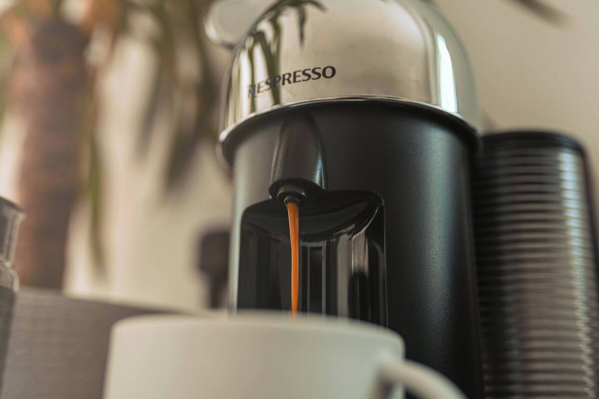 A Nespresso coffee machine with coffee being dispensed into a cup.