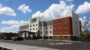 Un hôtel Holiday Inn Express doté d’un parking et offrant une vue sur un ciel dégagé.