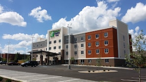 A Holiday Inn Express hotel with a parking lot and a clear sky. - Holiday Inn Express & Suites Lexington Midtown - I-75 by IHG (Lexington)