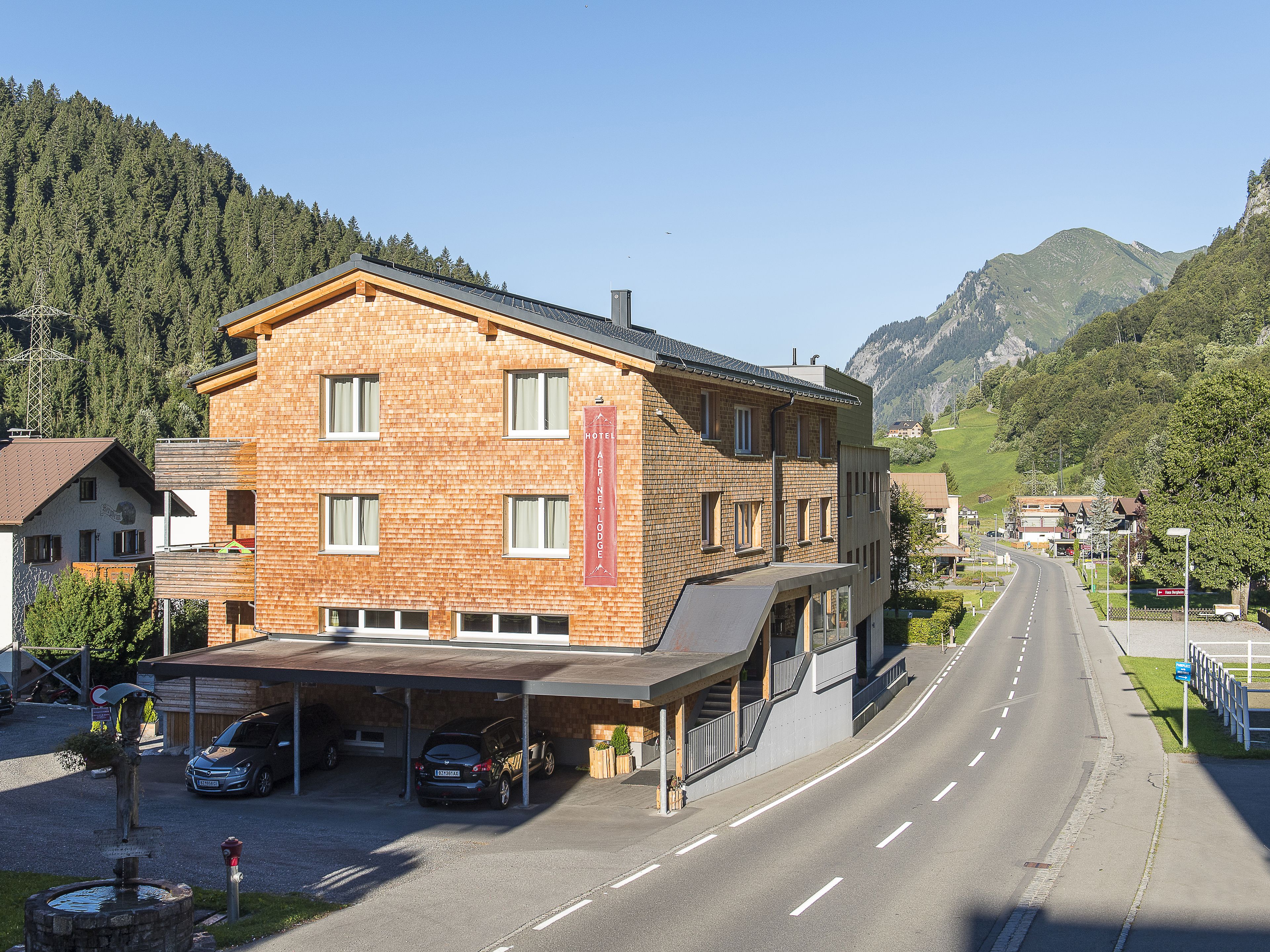A hotel with a brick facade, multiple windows, and a sign indicating it is an Alpine Lodge.