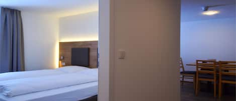 Quarto de hotel com cama, escrivaninha e cadeira.