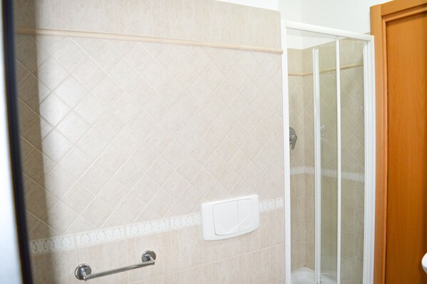 A shower area with a glass door, beige tiles, a handrail, and a white control panel. - Holiday Rendez Vous (Pineto)