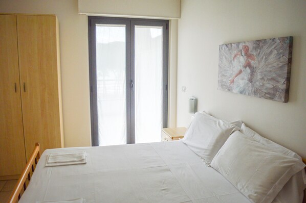 A bedroom with a bed, a wardrobe, a painting, and a door with a view. - Holiday Rendez Vous (Pineto)