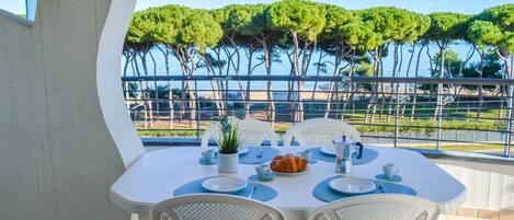 A table set for two with a view of trees and a body of water.