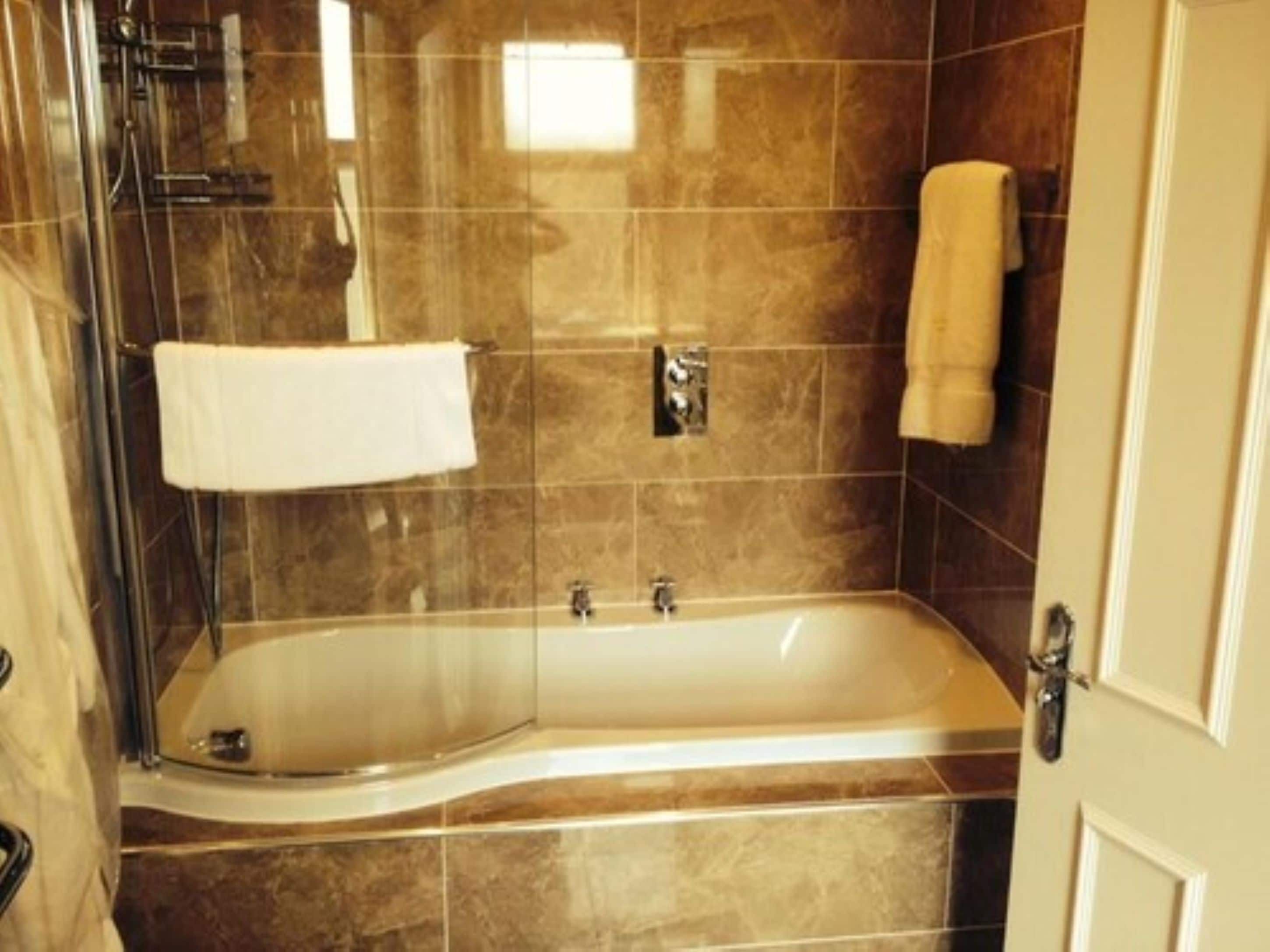 A modern bathroom with a freestanding bathtub, a glass shower enclosure, and a towel rack.