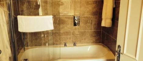 A modern bathroom with a freestanding bathtub, a glass shower enclosure, and a towel rack.