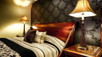 A hotel room with a bed, two bedside lamps, a nightstand, and a decorative wall.