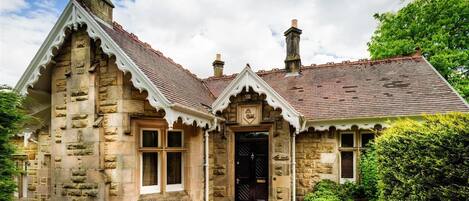 A stone building with a traditional design, featuring a prominent entrance and a chimney.