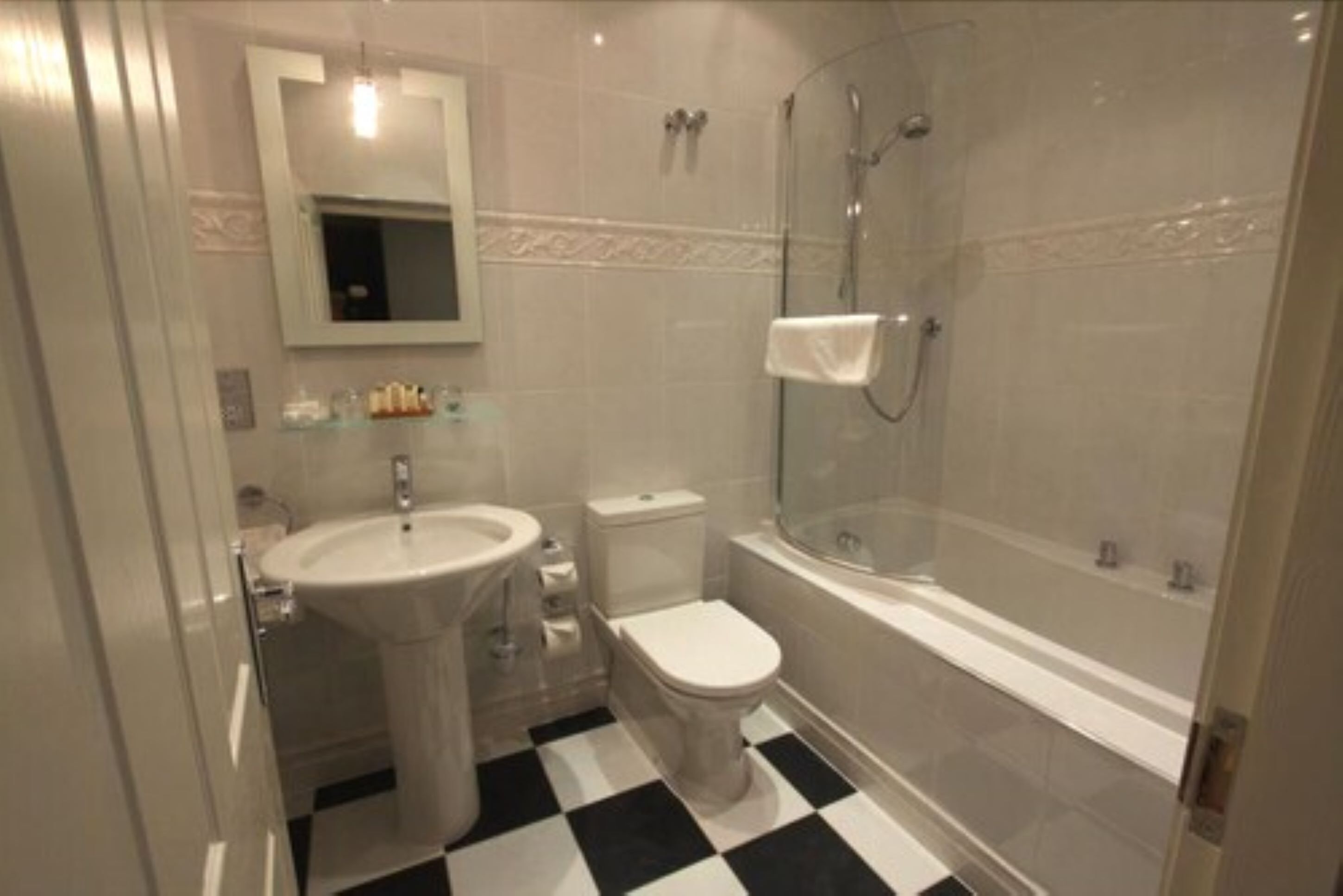 Un baño con lavamanos, inodoro y bañera.