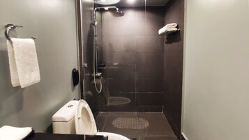Un baño pequeño y moderno con ducha de vidrio, inodoro y perchero para toallas.