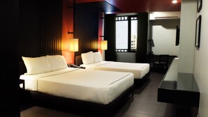 A hotel room with two beds, a desk, and a TV. - Amelie Hotel Manila (Manila)