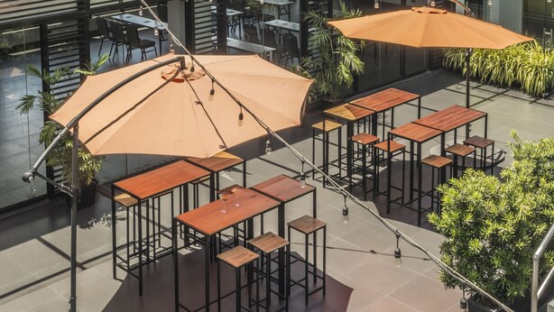 A rooftop terrace with outdoor seating, potted plants, and a city skyline view. - Amelie Hotel Manila (Manila)