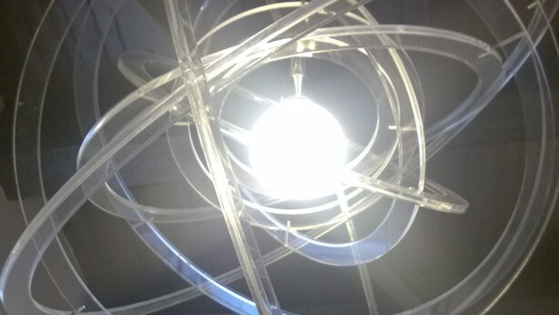 A ceiling with a circular light fixture featuring multiple transparent arms. - Talismano Luxury B&B (Naples)