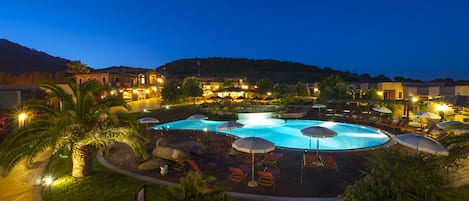 Una piscina al aire libre de temporada, sombrillas, tumbonas