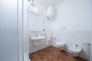 A bathroom with a sink, toilet, bidet, and a mirror. - Residence S'Incantu (Villasimius)