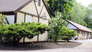 A traditional building with a pitched roof and a small window with shutters.