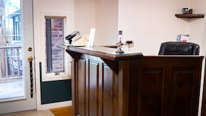 A reception desk with a telephone, a window, and a door.
