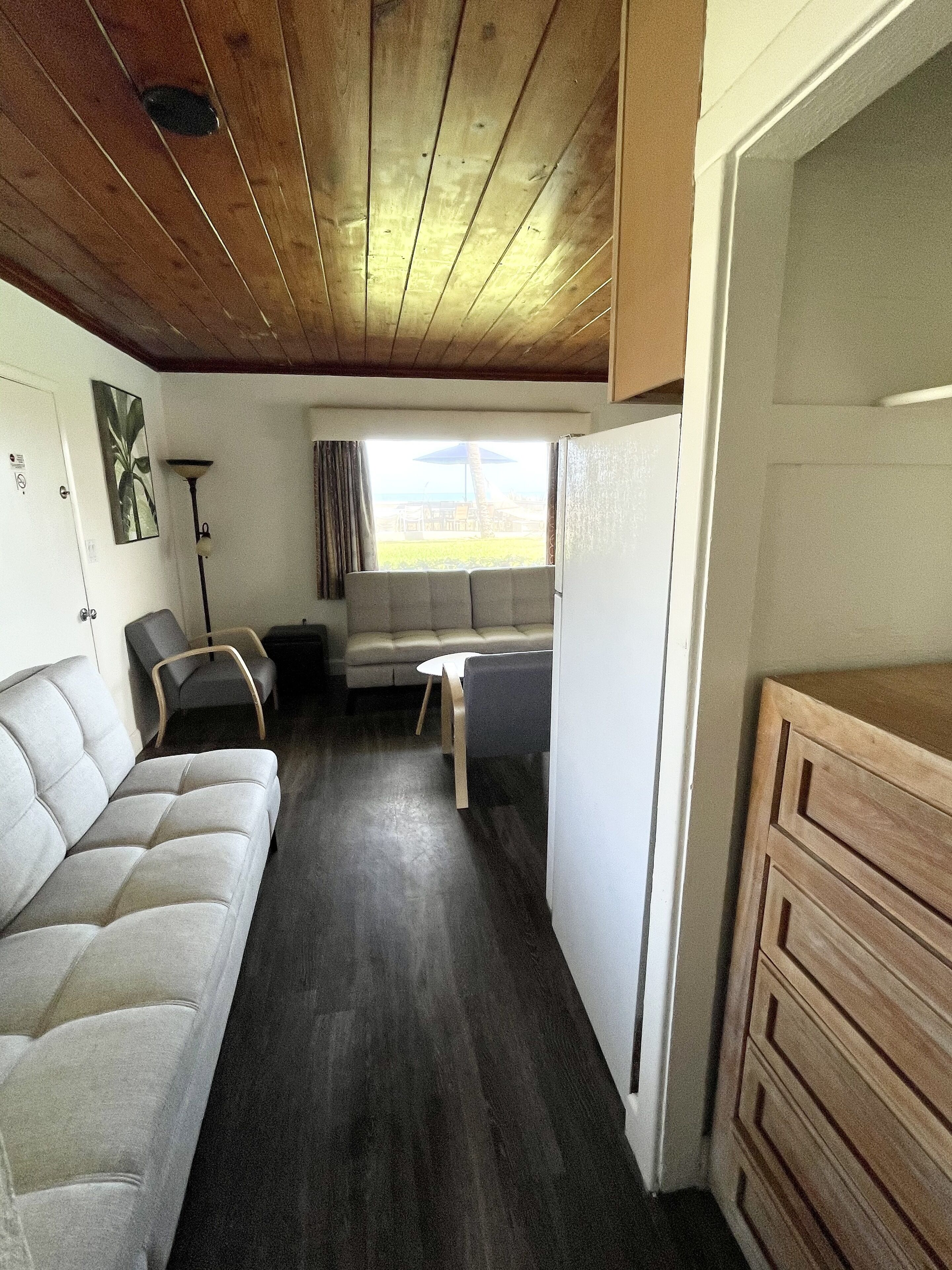A compact living space with a sofa, a dining table, and a kitchenette area.