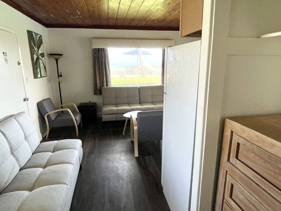 A compact living space with a sofa, a dining table, and a kitchenette area.