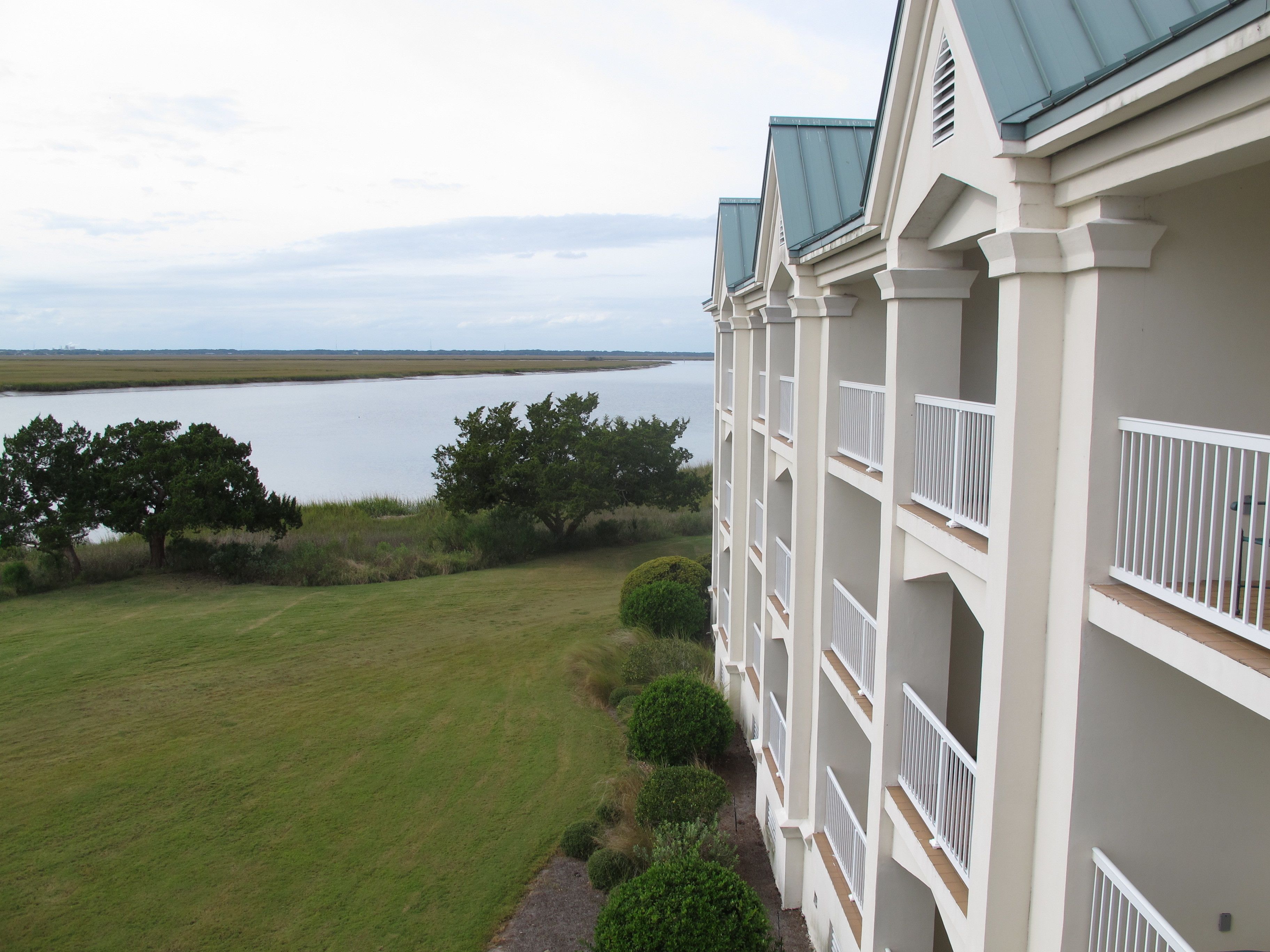 A hotel with a view of a lake and a grassy area.