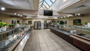 A spacious cafeteria with multiple food service stations, a large skylight, and a modern design. - Epworth By The Sea (St. Simons Island)