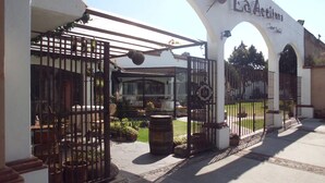Uma entrada com portão para um edifício, com um arco e uma placa que diz 'La Actividad'.