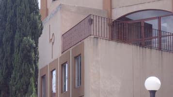 Un edificio con un letrero que dice "La Posadera" y un árbol alto en primer plano.