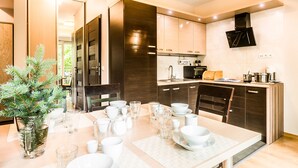 Une cuisine moderne avec des meubles en bois foncé, un four à micro-ondes encastré et un grand îlot central doté de sièges.